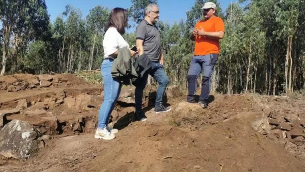 Natividade González, izquierda., y Xosé Penas con Costa en el yacimniento romano de O Castrillón, en Touro