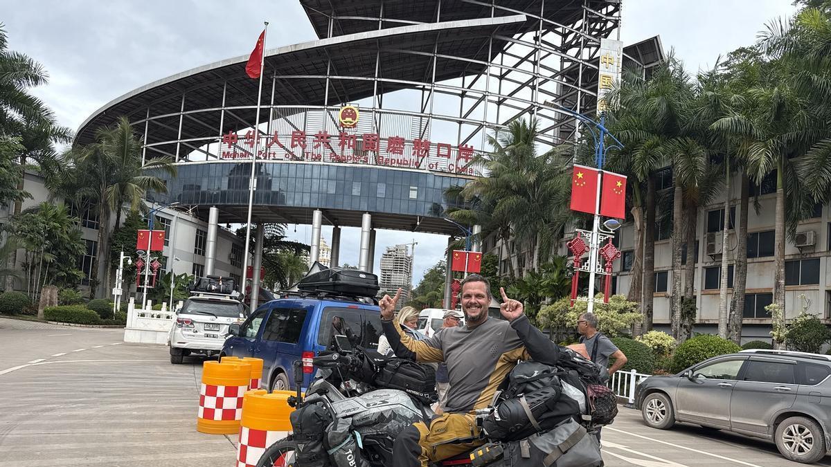 El malagueño Daniel Acedo, posa con su moto en la frontera entre China y Laos.