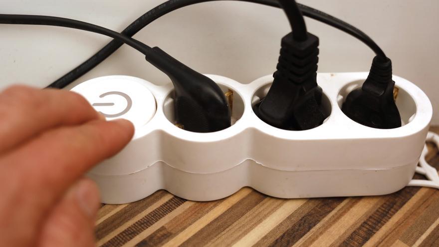 Una persona enciende una regleta con varios cables conectados