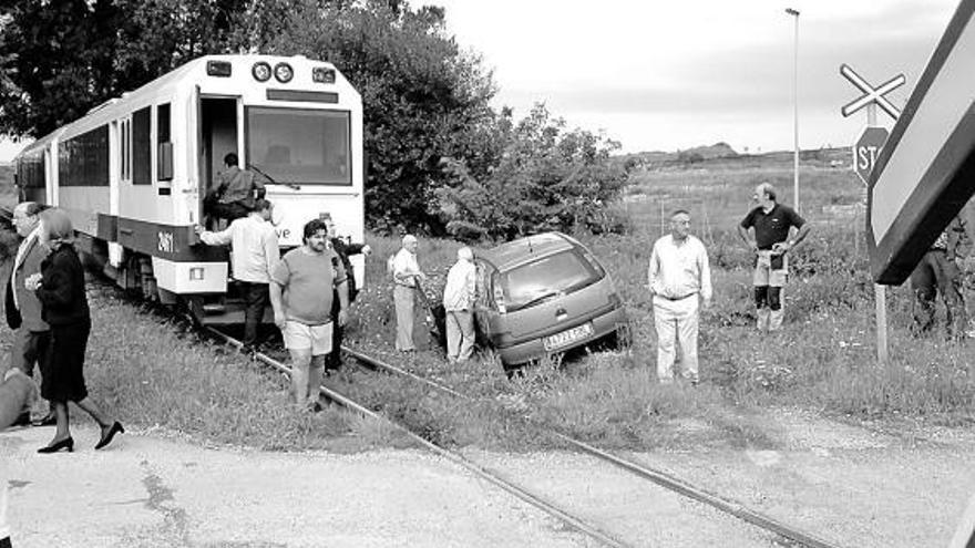 Vecinos, junto al convoy de Feve y el vehículo siniestrados en el paso a nivel próximo al tanatorio de Llanes.