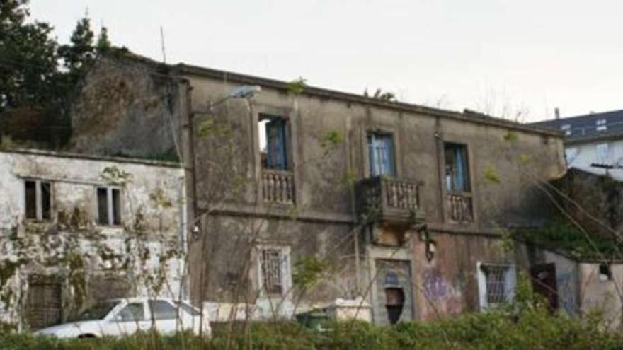 En el centro, edificio de la antigua sede del Ayuntamiento de Oza, situado en la calle Montes. / la opinión