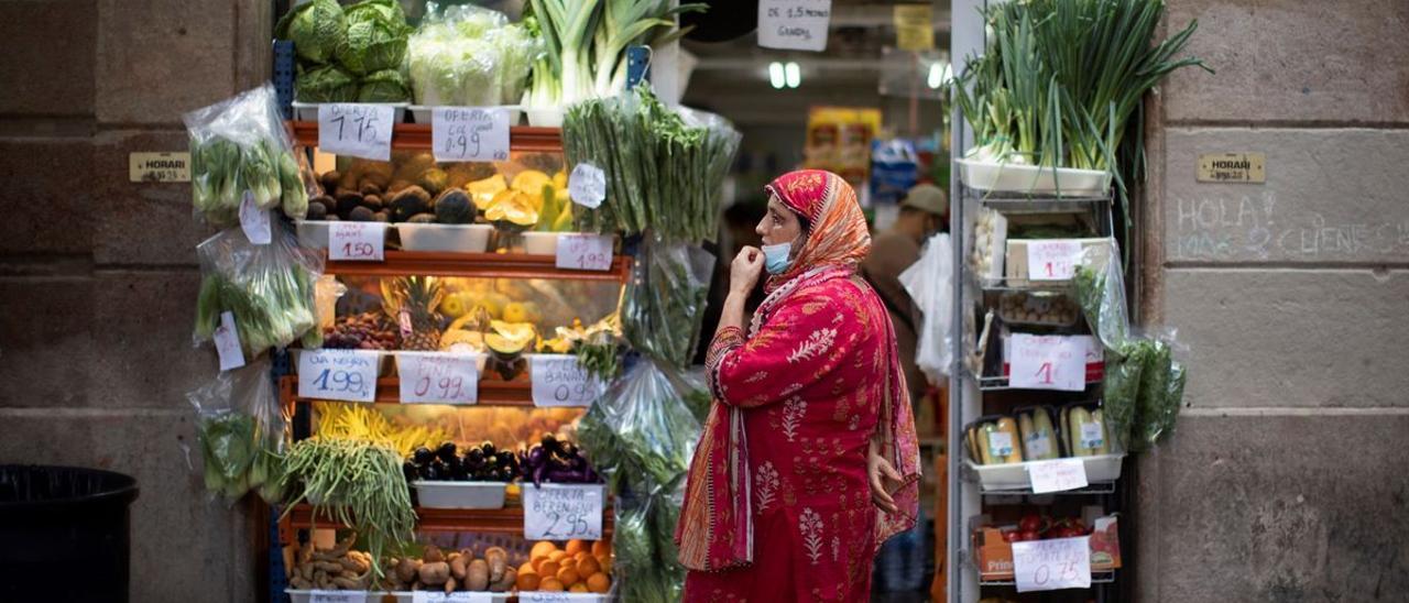 Una mujer delante de un supermercado del Raval.