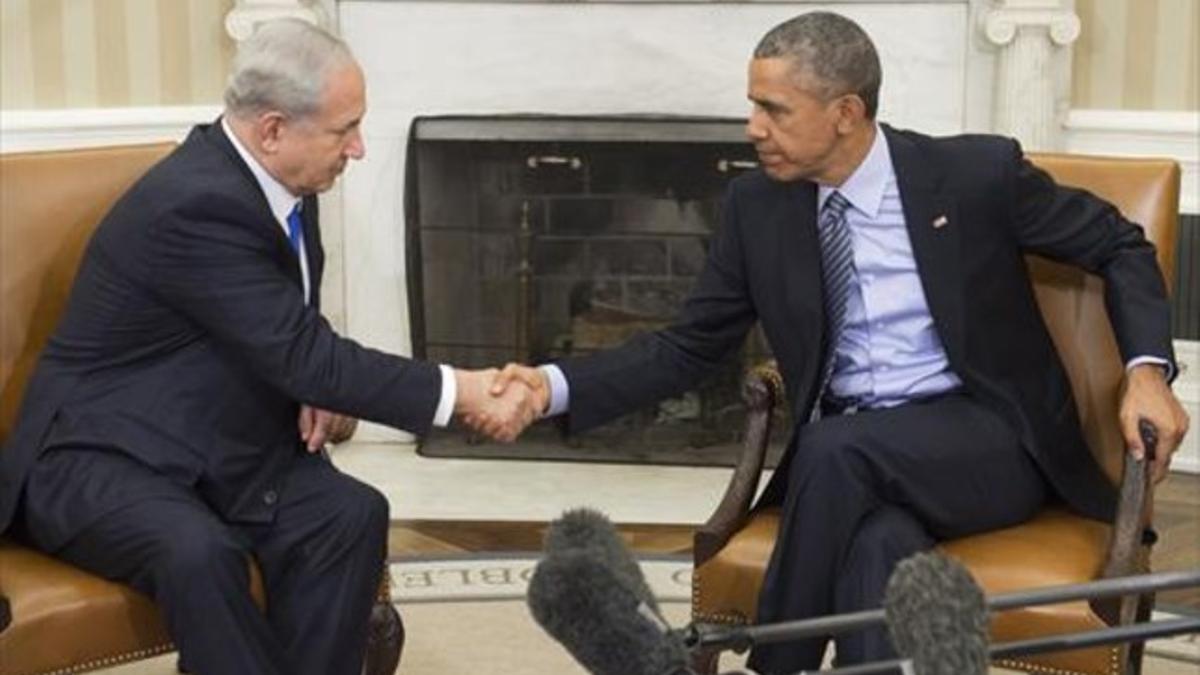 Obama y Netanyahu se saludan al inicio de su encuentro en el despacho Oval de la Casa Blanca, ayer.