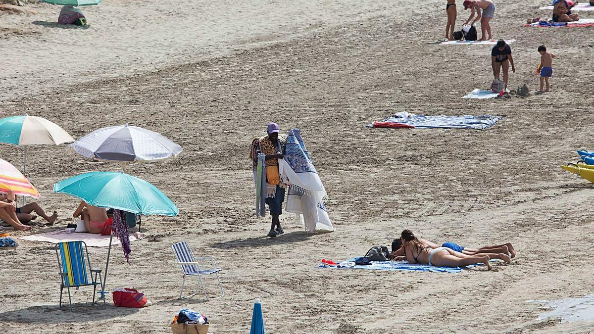 Uno de los vendedores ambulantes muestra sus pareos, este domingo en ses Salines. | VICENT MARÍ