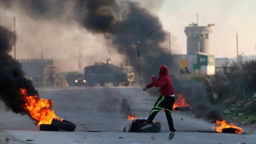 Un palestino lanza piedras contra las tropas israelíes en Ramala.