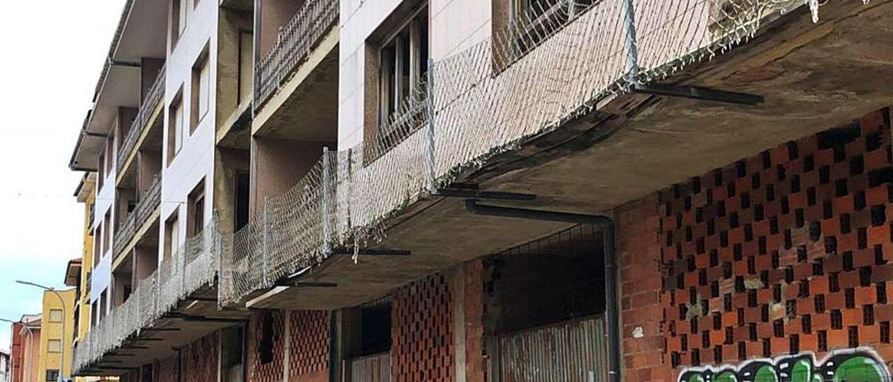 El edificio de la calle Celso Amieva, con medidas de contención para frenar la caída de cascotes.