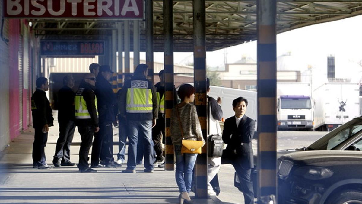 Agentes de la Policía Nacional y ciudadanos chinos, durante el registro a negocios en el polígono industrial Cobo Calleja, en Fuenlabrada.