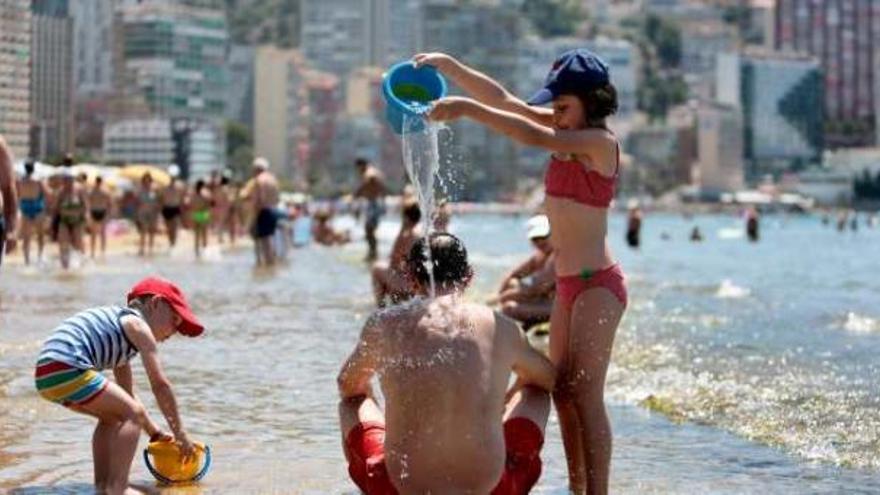 Turistas tomando el baño en la playa de Levante de Benidorm, ayer, para aliviarse del sofoco provocado por las altas temperaturas.