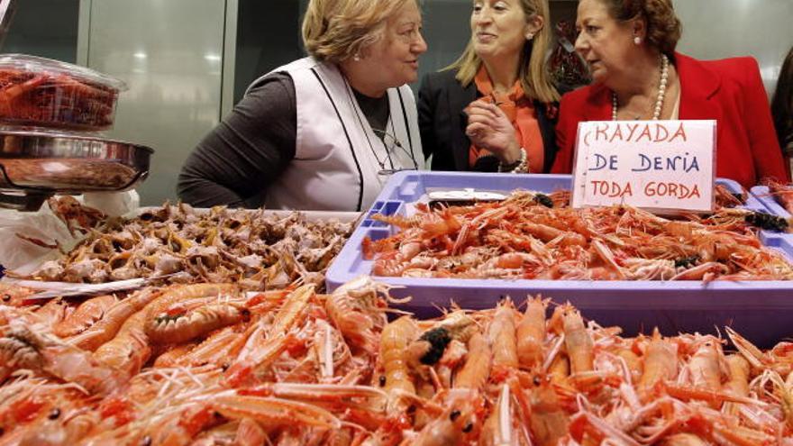 La ministra de Fomento, Ana Pastor y la alcaldesa de Valencia, Rita Barberá, conversan con una vendedora del Mercado Central de Valencia.