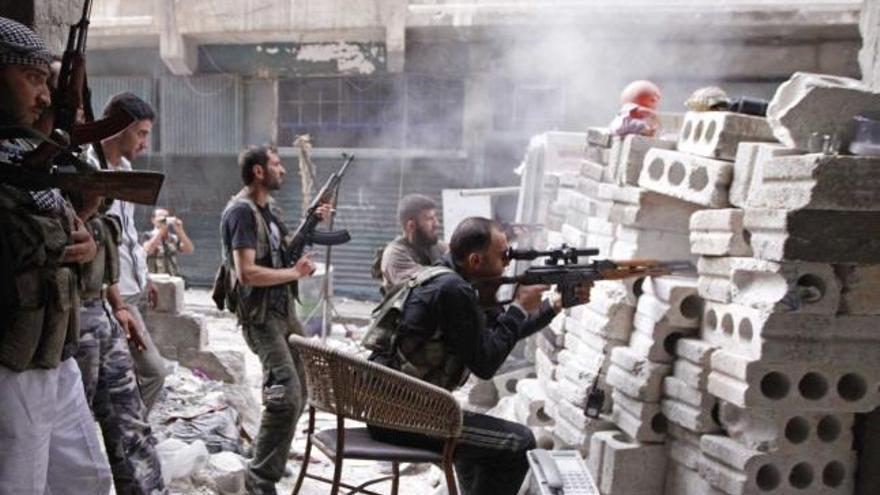Miembros del Ejército Libre Sirio, en Alepo, parapetados tras una barricada de ladrillos.