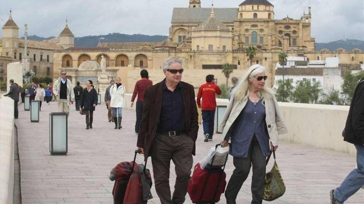 Turistas pasean en el Puente Romano de Córdoba, en una imagen de archivo.