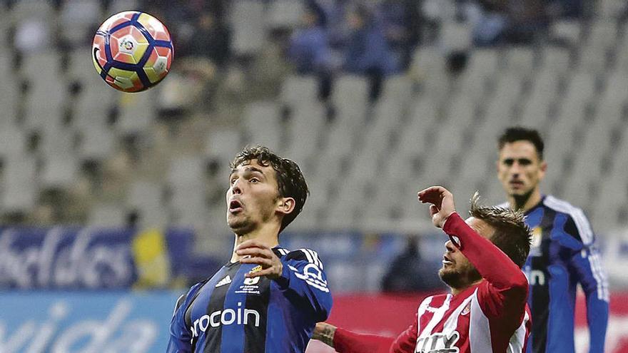 Lucas Torró controla el balón ante la presencia de Portu, el sábado en el partido del Carlos Tartiere.