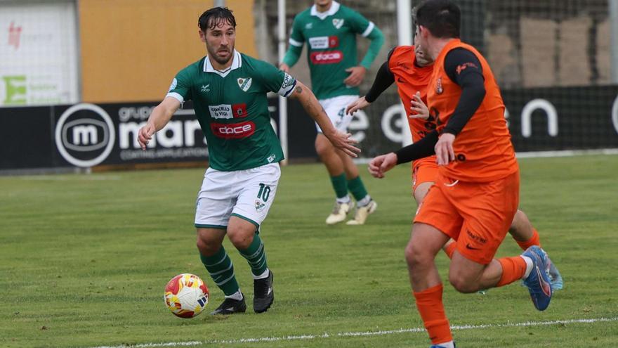 David Añón, del Coruxo, conduce el balón ante un jugador del Sámano. |  José Lores