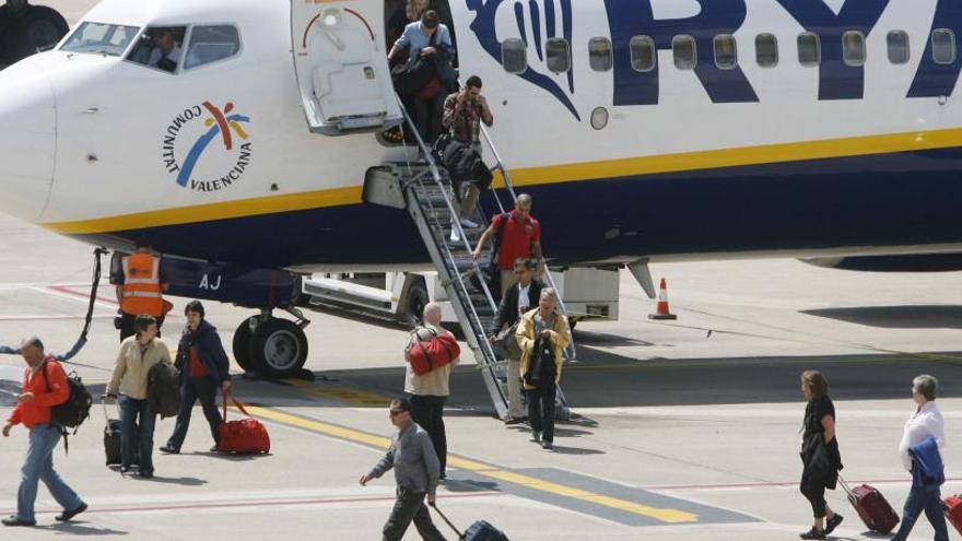 Passatgers amb les seves maletes baixant d&#039;un avió de Ryanair a Girona