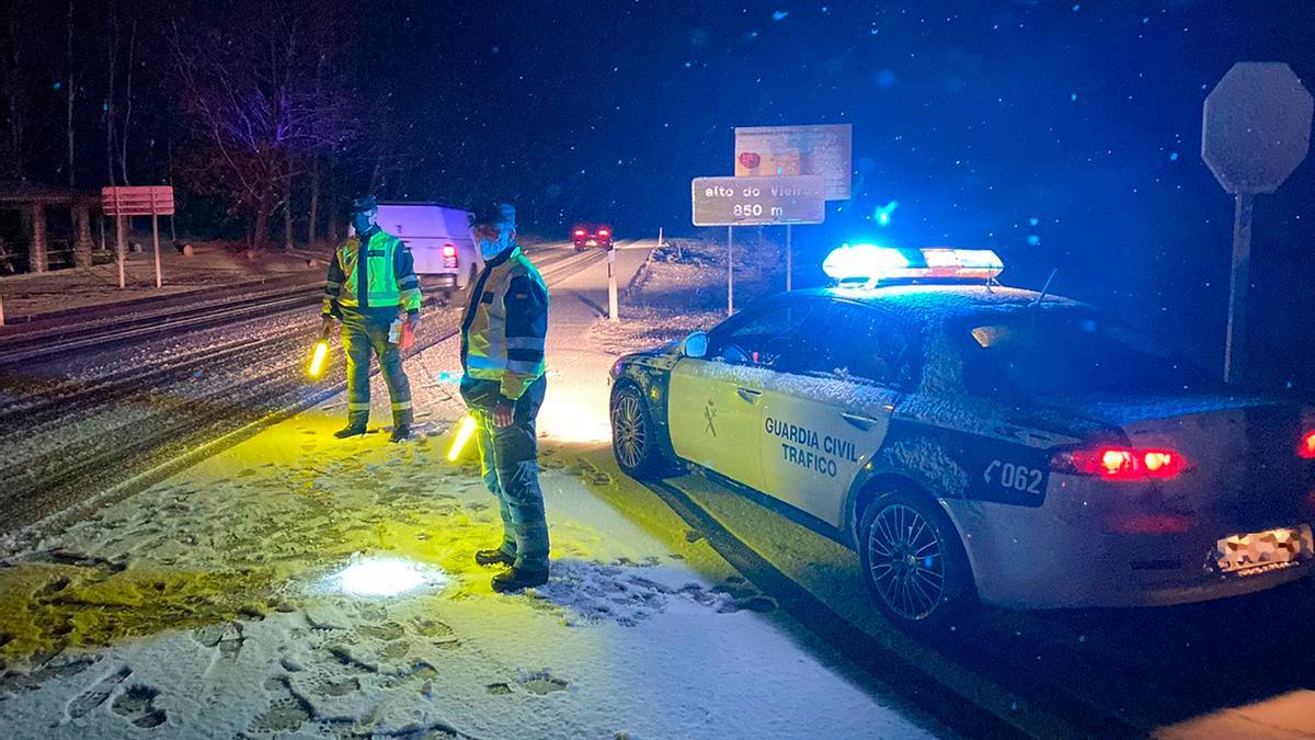 Agentes de la Guardia Civil de Tráfico, bajo la nieve, en Bande