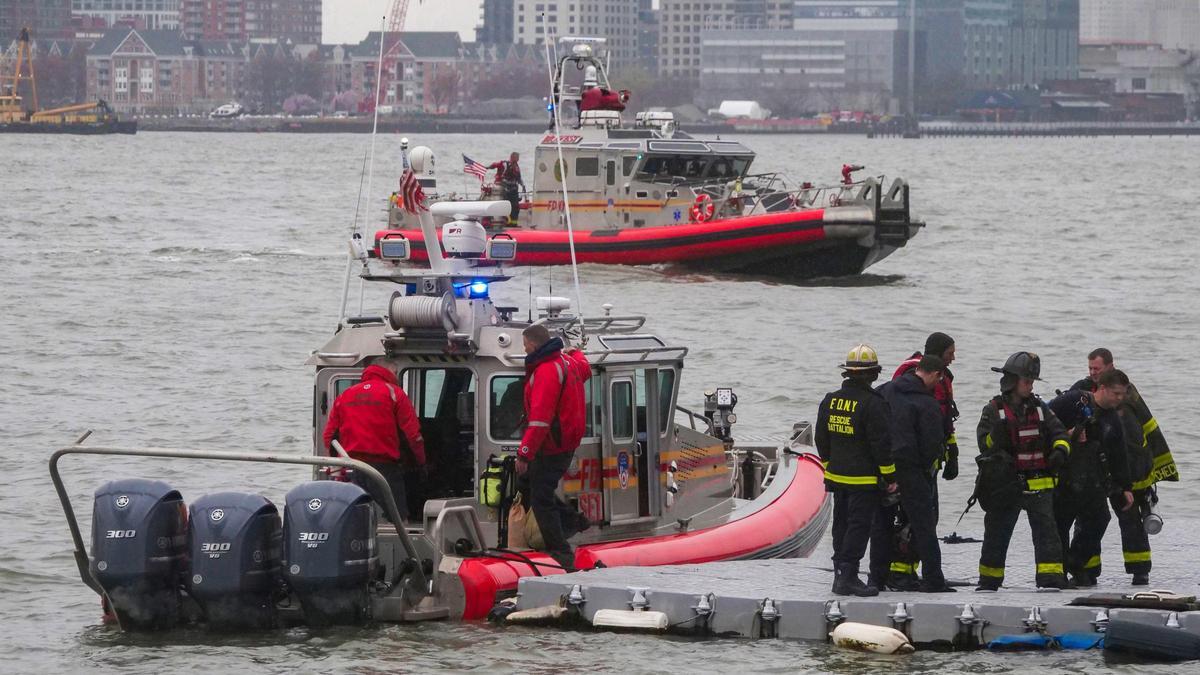 Los buzos del Departamento de Bomberos de Nueva York regresan al muelle 40 en la costa de Nueva York mientras los barcos de rescate buscan el helicóptero turístico que se estrelló sobre el río Hudson