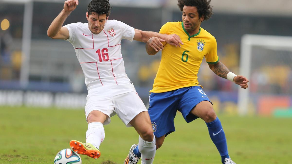 Milos Jojic pugna con Marcelo durante un partido amistoso de Serbia contra Brasil.