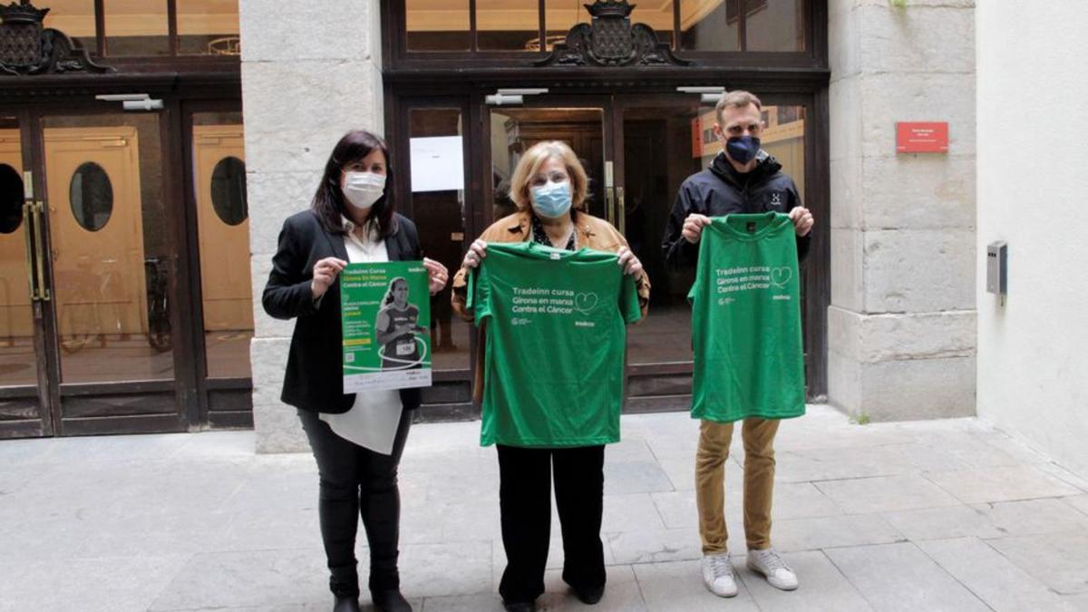 Els organitzadors amb la samarreta i el cartell de la marxa. | AJ. DE GIRONA