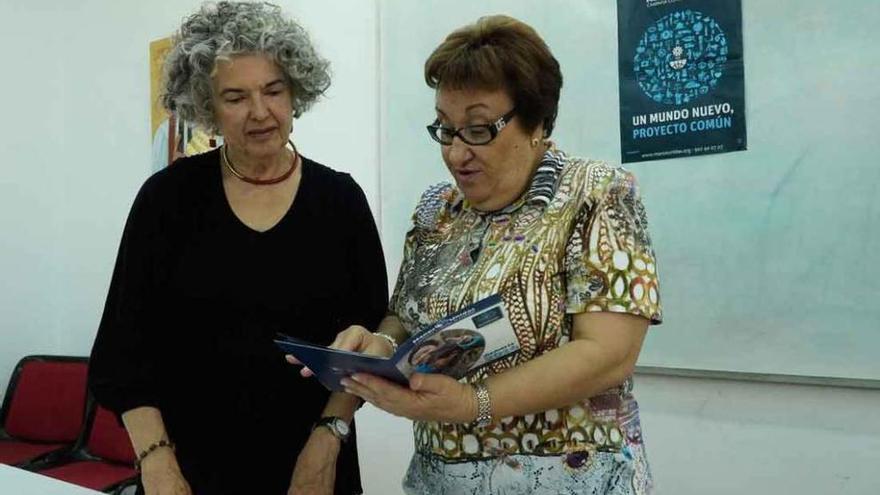 Milagros Morata (izquierda) y Pilar Gutiérrez revisan la memoria de Manos Unidas de 2014.