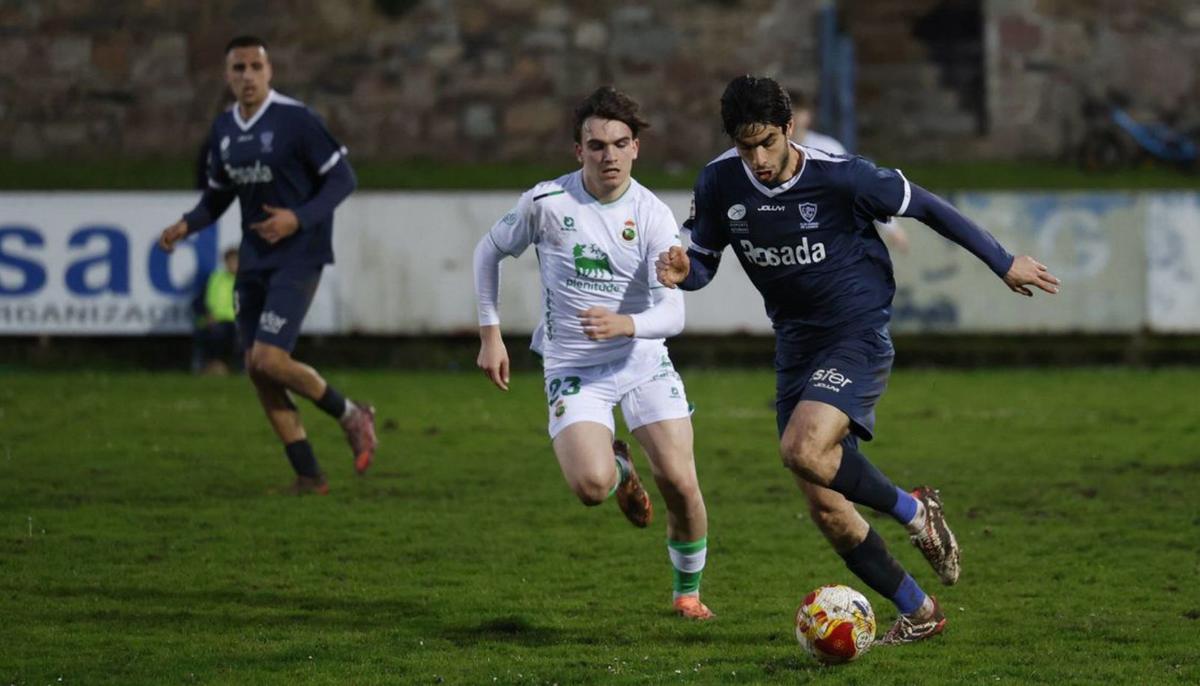 Tomás Fuentes, del Marino, con el balón, perseguido por Javi García.  |