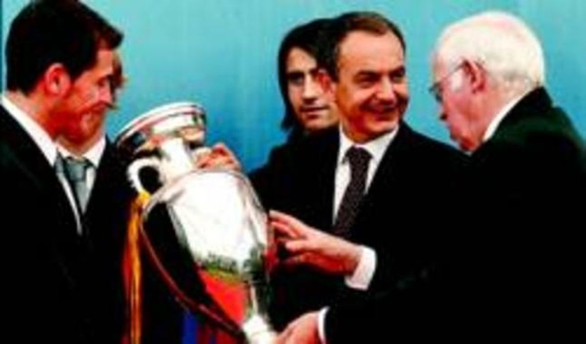 Zapatero sosté la copa davant Casillas mentre xerra amb el seleccionador espanyol. Zapatero sosté la copa davant Casillas mentre xerra amb el seleccionador espanyol.