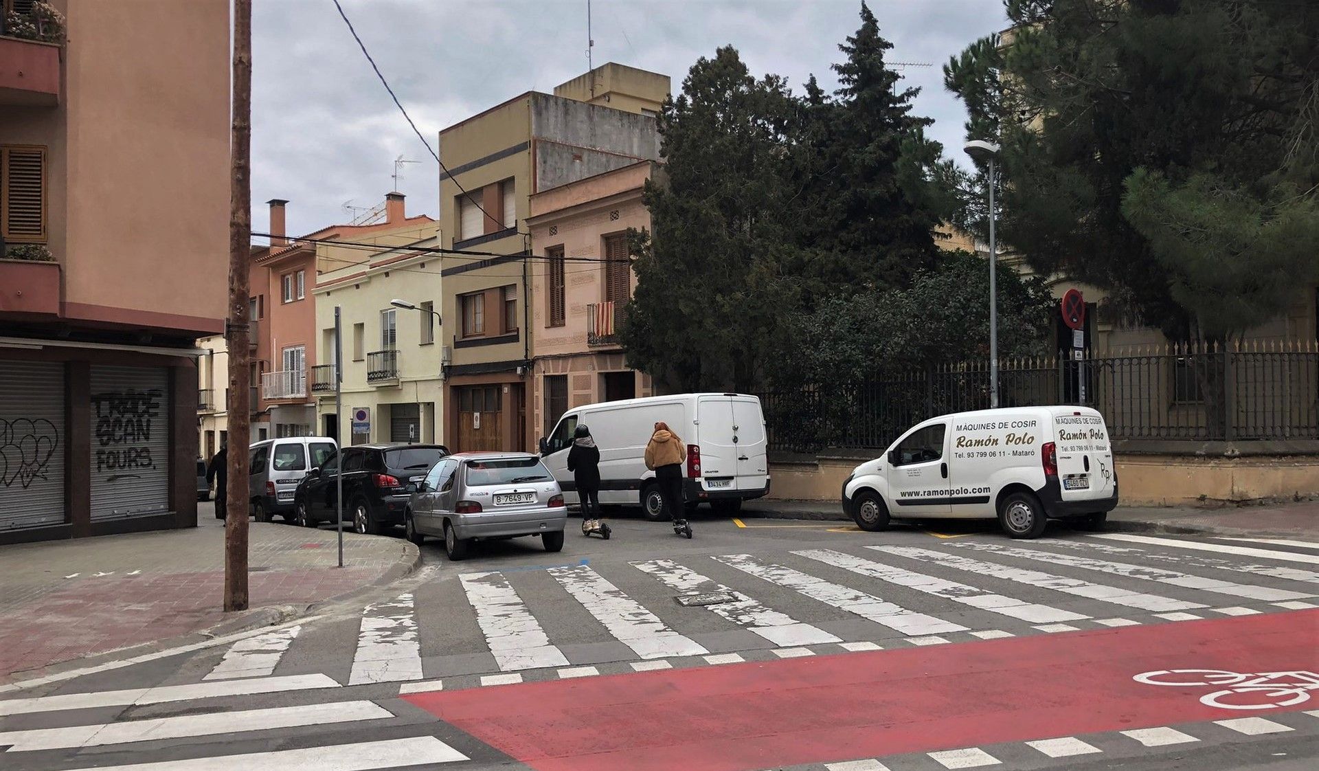 Dos personas en patinete eléctrico en el cruce entre calle de Jaume Isern y calle de Tetuan de Mataró.