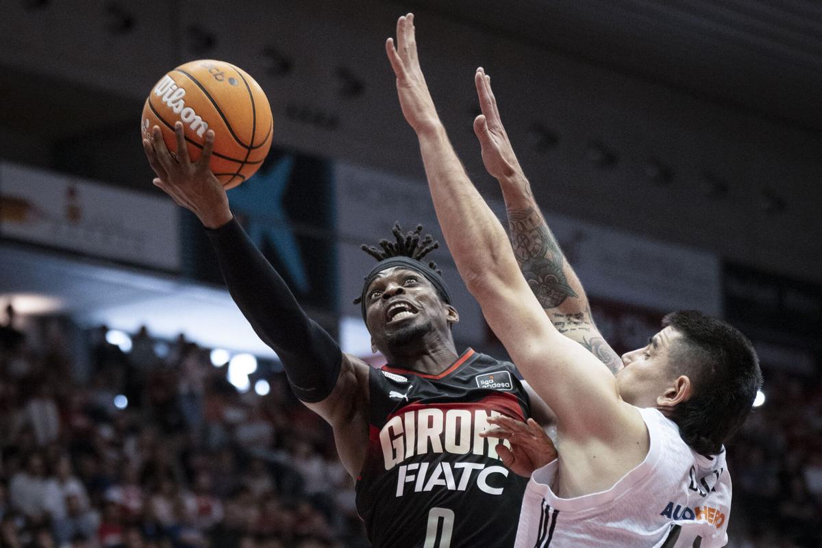 Ike Iroegbu, del Basquet Girona, ante Gabriel Deck, del Real Madrid, durante el partido de Liga Endesa que ambos equipos disputaron en el Pabellón de Fontajau de Girona. EFE/David Borrat
