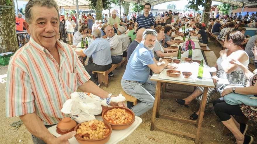 Un hombre porta dos raciones de callos durante una pasada edición de la fiesta. // Iñaki Abella