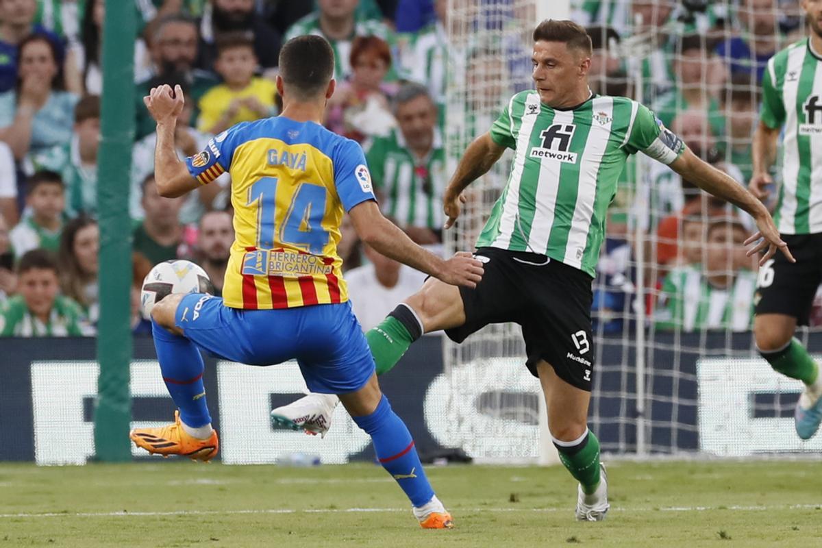 El centrocampista del Betis, Joaquín Sánchez (d), disputa el balón ante el defensa del Valencia, José Gayá, durante el encuentro correspondiente a la última jornada de primera división que disputan en el estadio Benito Villamarín de Sevilla. EFE/José Manuel Vidal.