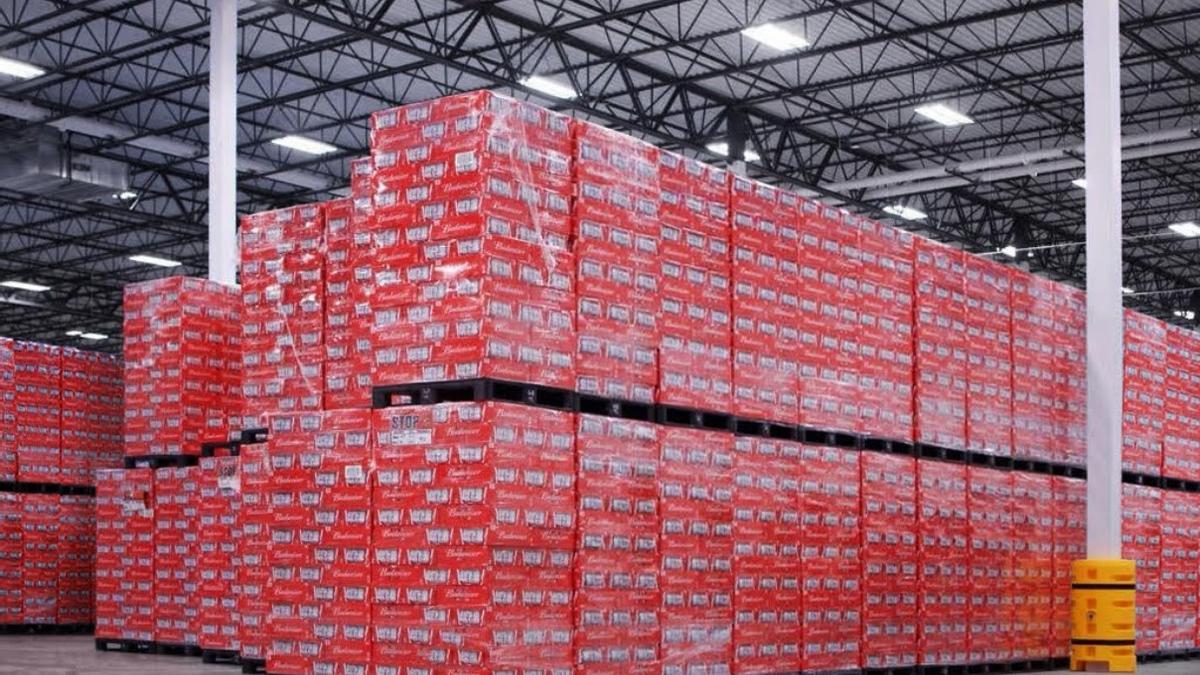 Miles de latas de cerveza de Budweiser apiladas en un almacén.