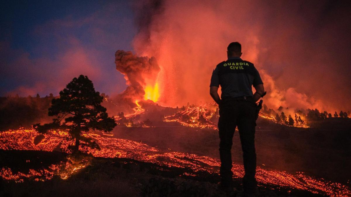 Un Guardia Civil contempla la destrucción de la lava del volcán de La Palma durante la erupción.