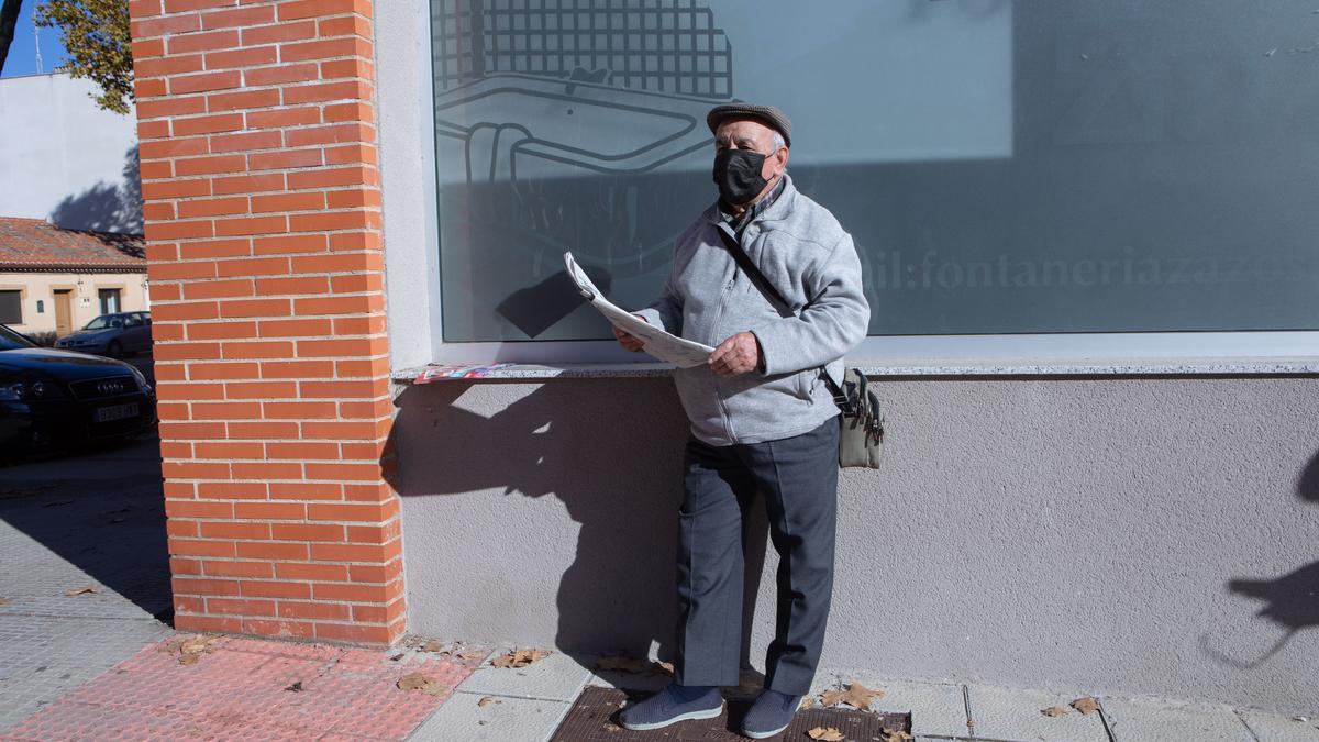 Antonio Merchán lee la prensa apoyado sobre la fachada.