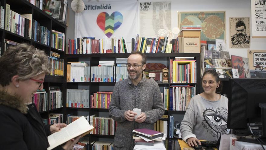 Liliana Castañón, a la izquierda, ojea un libro junto a Miguel Gallardo y Eva Rodríguez en la librería-café La Llocura. | Fernando Rodríguez