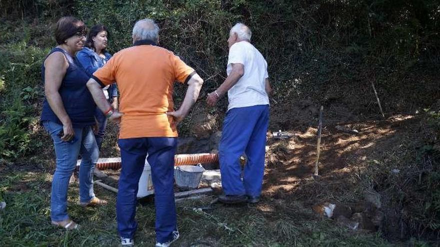 Barciela y Amoedo contemplan la canalización de la nueva fuente. // FdV