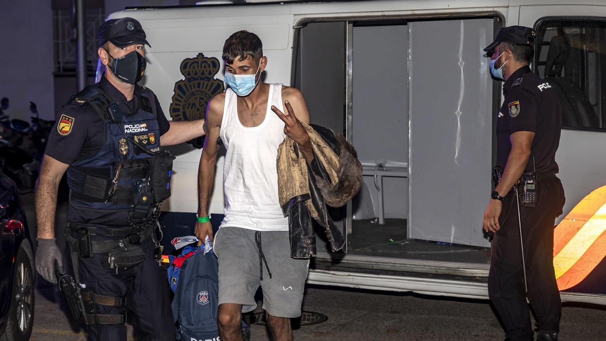 Beamte der spanischen Nationalpolizei begleiten einen von Algerien aus auf die Insel übergesetzten jungen Mann.