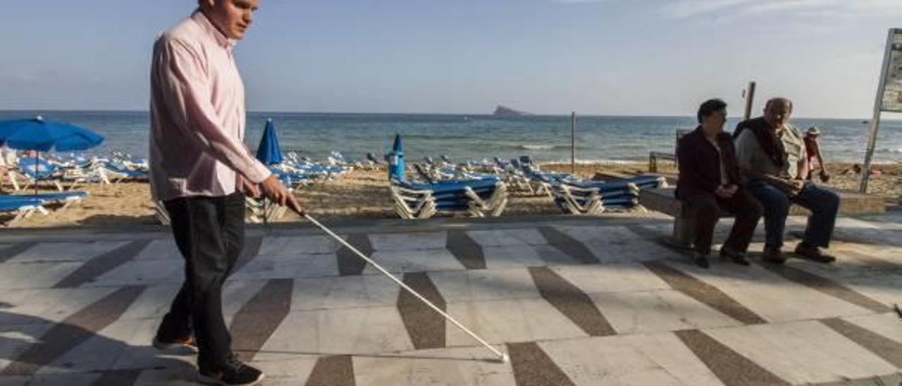 Quico, paseando junto a la playa de Levante, ayudado de su bastón y del sonido del mar.