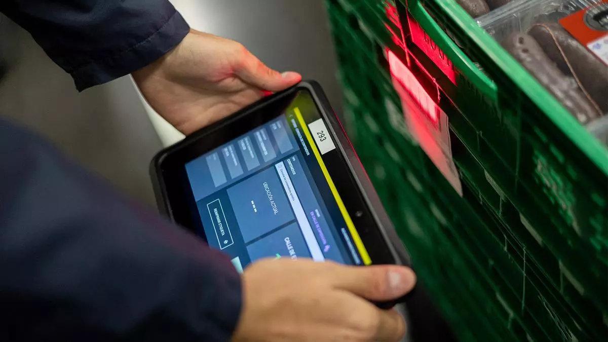 Un empleado de Mercadona sujeta una tableta.
