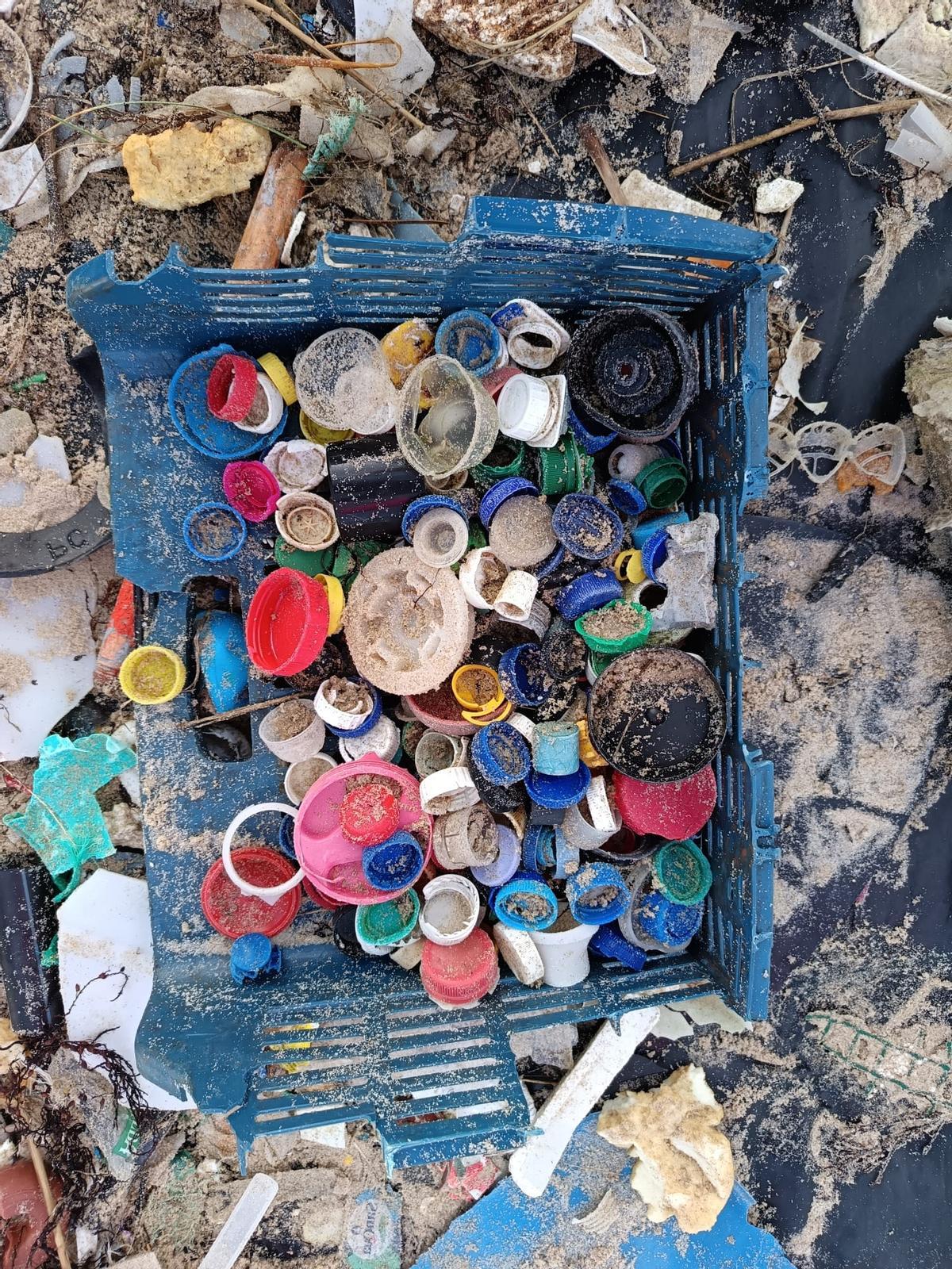 'Colleita' de tapóns plásticos na praia de Traba de Laxe.