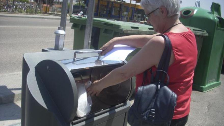 Una mujer deposita la bolsa de basura en uno de los contenedores de Morales.