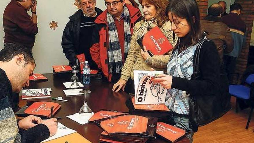 Luis Davila firmando libros.