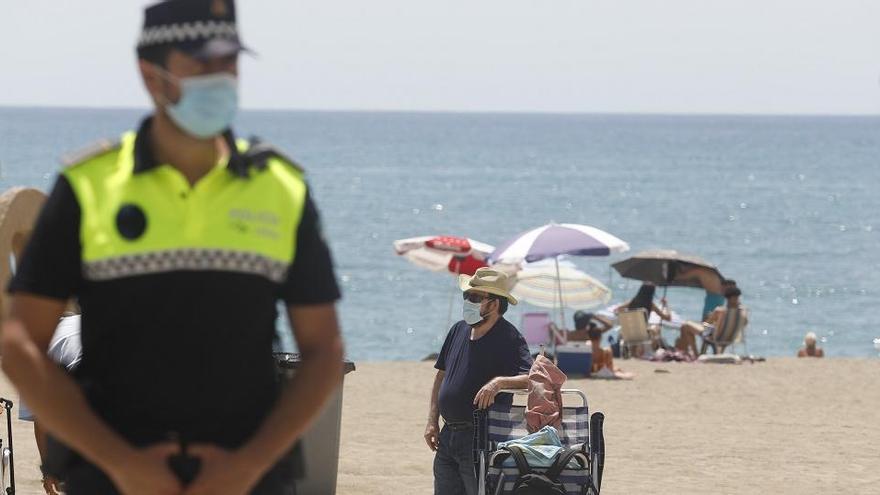 Un policía local con mascarilla en una playa de la capital.