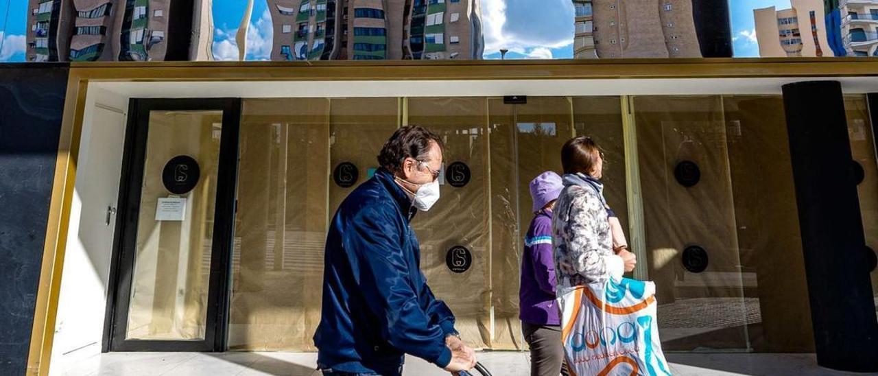 Una mujer observa la fachada de un hotel cerrado en la ciudad de Benidorm. | DAVID REVENGA