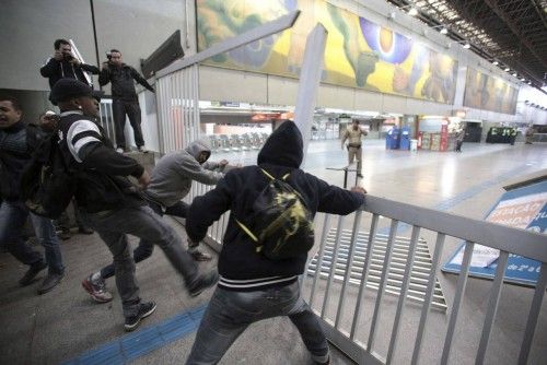 Commuters break an entrance gate at Itaquera subway station in Sao Paulo