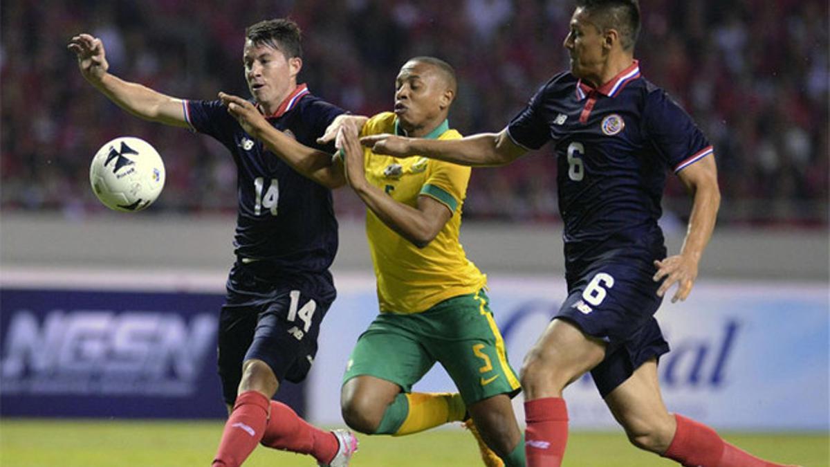 Bryan Oviedo y Oscar Duarte (Costa Rica) pelean el balón con Andile Jail, autor del gol de Sudáfrica