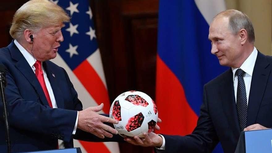 Trump recibe de manos de Putin un balón del Mundial de Rusia. // AFP