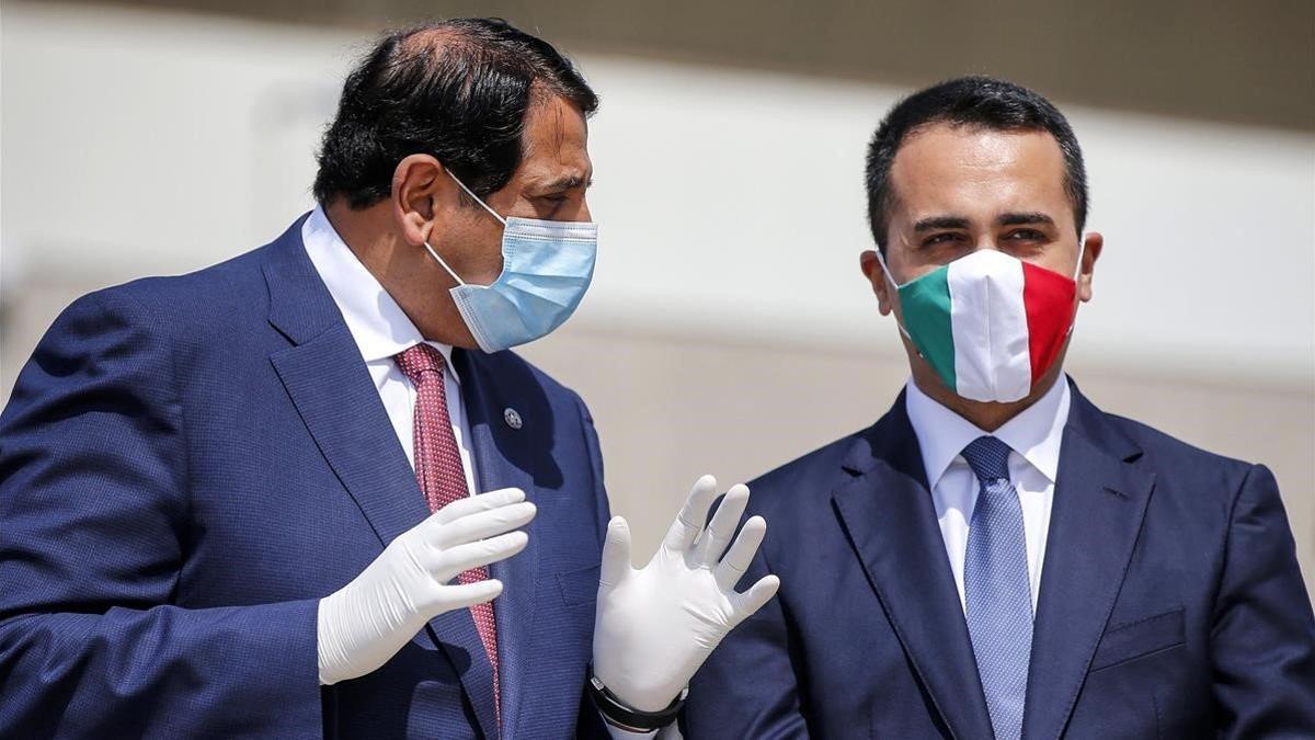 El ministro de Exteriores italiano, Luigi di Maio, luce una máscara protectora con los colores de la bandera italiana al dar la bienvenida al embajador de Qatar en Italia, Abdulaziz bin Ahmed Al Malki durante la llegada de un vuelo con ayuda médica d