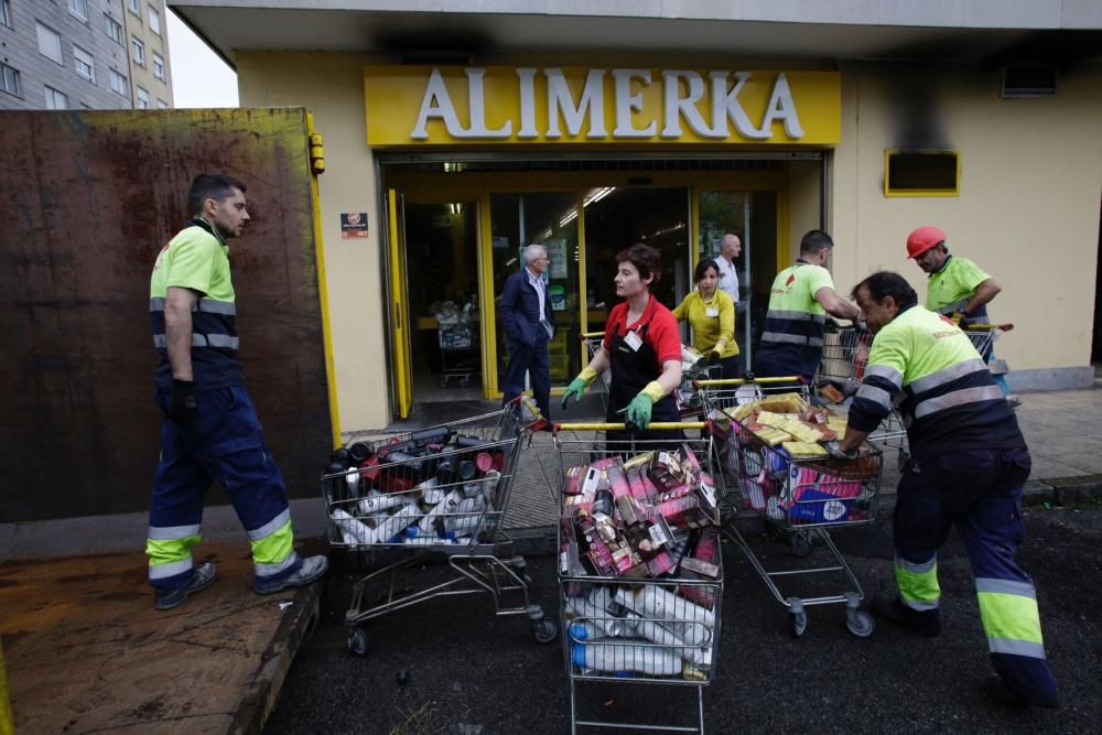 Labores de limpieza tras el incendio en un supermercado de La Tenderina.