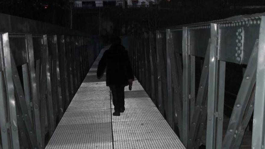 Un vecino, caminando por el puente de Marianes.