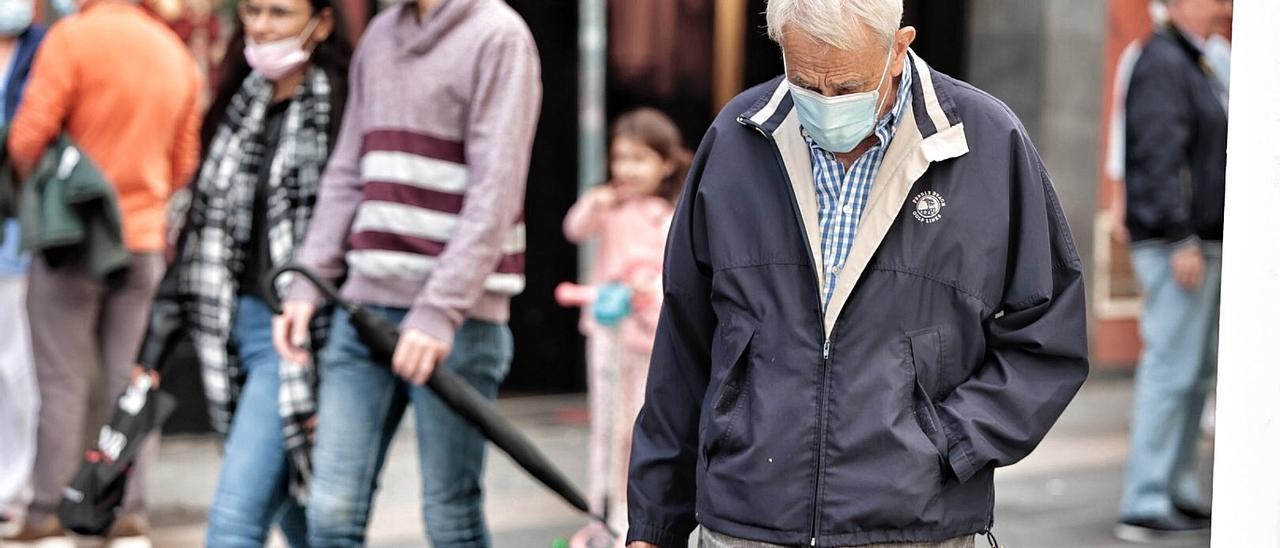 Varias personas con mascarilla pasean por Santa Cruz de Tenerife.