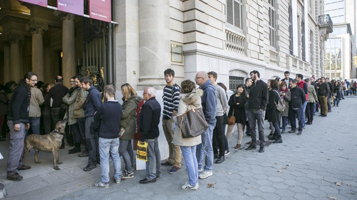 COLAS TRAS UNA SEMANA. Decenas de ciudadanos esperan ante el Palau Robert para participar en la consulta del 9-N, este sábado.